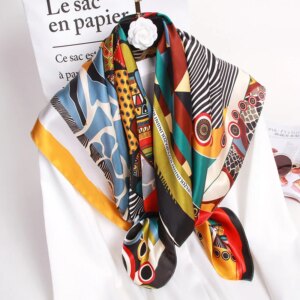 Photo d'un foulard en soie véritable multicolore à motifs noué autour d'une chemise blanche.