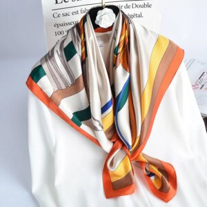 Photo d'un foulard en soie véritable aux couleurs automnales, noué autour d'une chemise blanche.