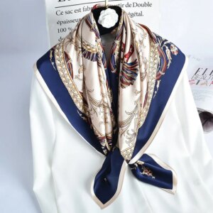 Photo d'un foulard en soie véritable beige et bleu marine noué autour d'une chemise blanche.
