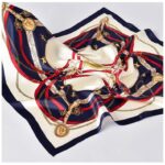 Photo d'un foulard en soie carré bleu, blanc, rouge à motifs.