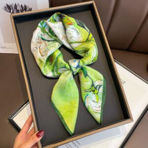 Foulard carré d'été aux tons vert en soie de luxe pour femme posé dans sa boite d'achat