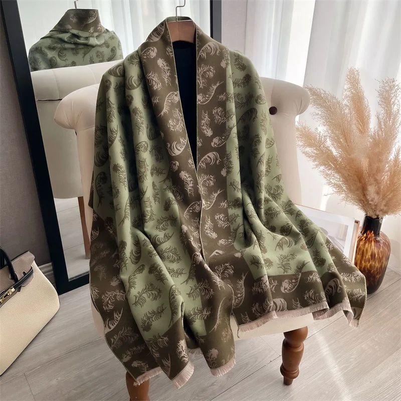 echarpe dans les tons verts, imprimée de plumes, posée sur une chaise comme un châle, devant un miroir.