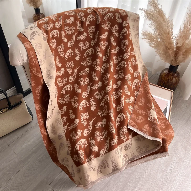 écharpe orange imprimée de plumes beige, déposée sur une chaise.